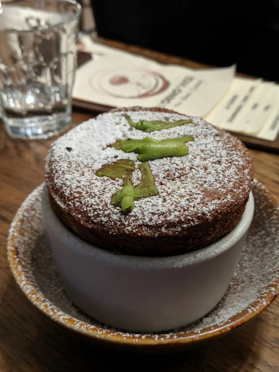 Soufflé sucré servi en ramequin, sucre glace et pistache
