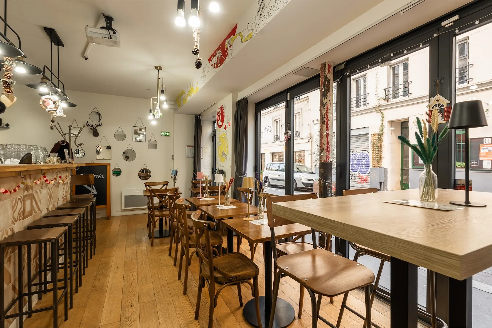 La salle de L'Œno'Vice, comptoir, tabourets, tables en bois et grandes baies sur la rue
